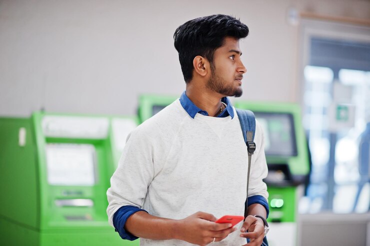 Young Stylish Asian Man With Mobile Phone Backpack Against Row Green Atm 627829 1114